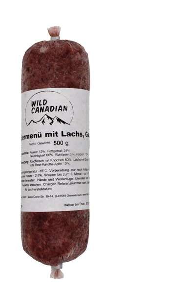 Eine Frostfleischrolle mit weißem Etikett und der Aufschrift „Farmenü mit Lachs, Geflügel“. Verpackt in einem nicht essbaren Kunstdarm. Die Füllung ist fein gewolft und zeigt eine rotbraune Farbe mit vereinzelten helleren Einschlüssen.