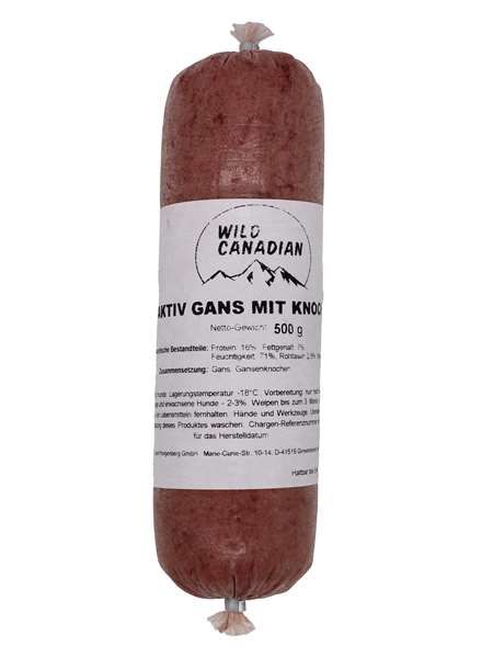 Eine Frostfleischrolle mit weißem Etikett und der Aufschrift „Wild Canadian Aktiv Gans mit Knochen 500 g“. Verpackt in einem nicht essbaren Kunstdarm. Die Füllung ist fein gewolft und zeigt eine dunkelrotbraune Masse mit leicht unregelmäßiger Struktur.