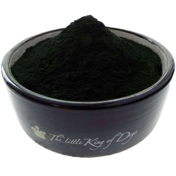 Eine schwarze Schale, gefüllt mit einem feinen, dunkelgrünen Pulver, das kuppelförmig aufgeschüttet ist.