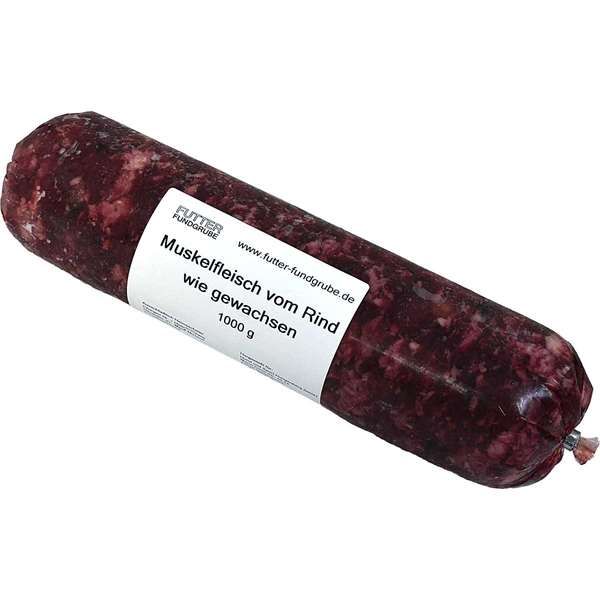 Eine vakuumverpackte, dunkelrote Wurstrolle, verpackt in einem nicht essbaren Kunstdarm, liegt quer im Bild. Auf dem weißen Etikett steht „Muskelfleisch vom Rind wie gewachsen – 1000 g“. Die Rolle enthält rohes Rindermuskelfleisch