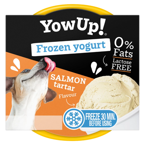 Gefrorener Joghurt-Snack mit Lachs-Tatar-Geschmack. Laktosefrei und fettfrei. Inhalt: 110 g. In runder Kunststoffverpackung mit schwarzem Deckel, orange-schwarzem Etikett, sichtbarem weißem Joghurt und Abbildung eines Hundes.
