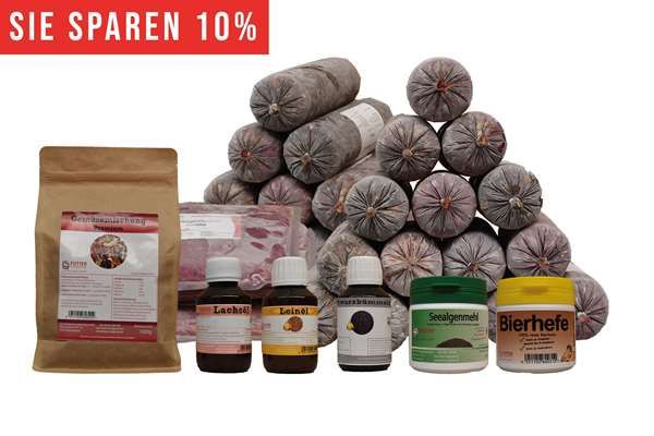Ein BARF-Paket mit pyramidenförmig gestapelten Frostfleischrollen im Kunstdarm. Davor eine Papiertüte, zwei flache Beutel und sechs Ergänzungsprodukte. Oben links ein rotes Banner mit weißer Aufschrift „Sie sparen über 10 %“.