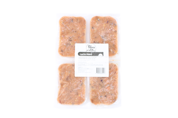 Vier einzeln portionierte Fleischstücke im Vakuum-Pack mit weißem Etikett und der Aufschrift „Lachs Menü“. Die Füllung ist fein gewolft, hellorange mit dunklen Einschlüssen und leicht unregelmäßiger Struktur.